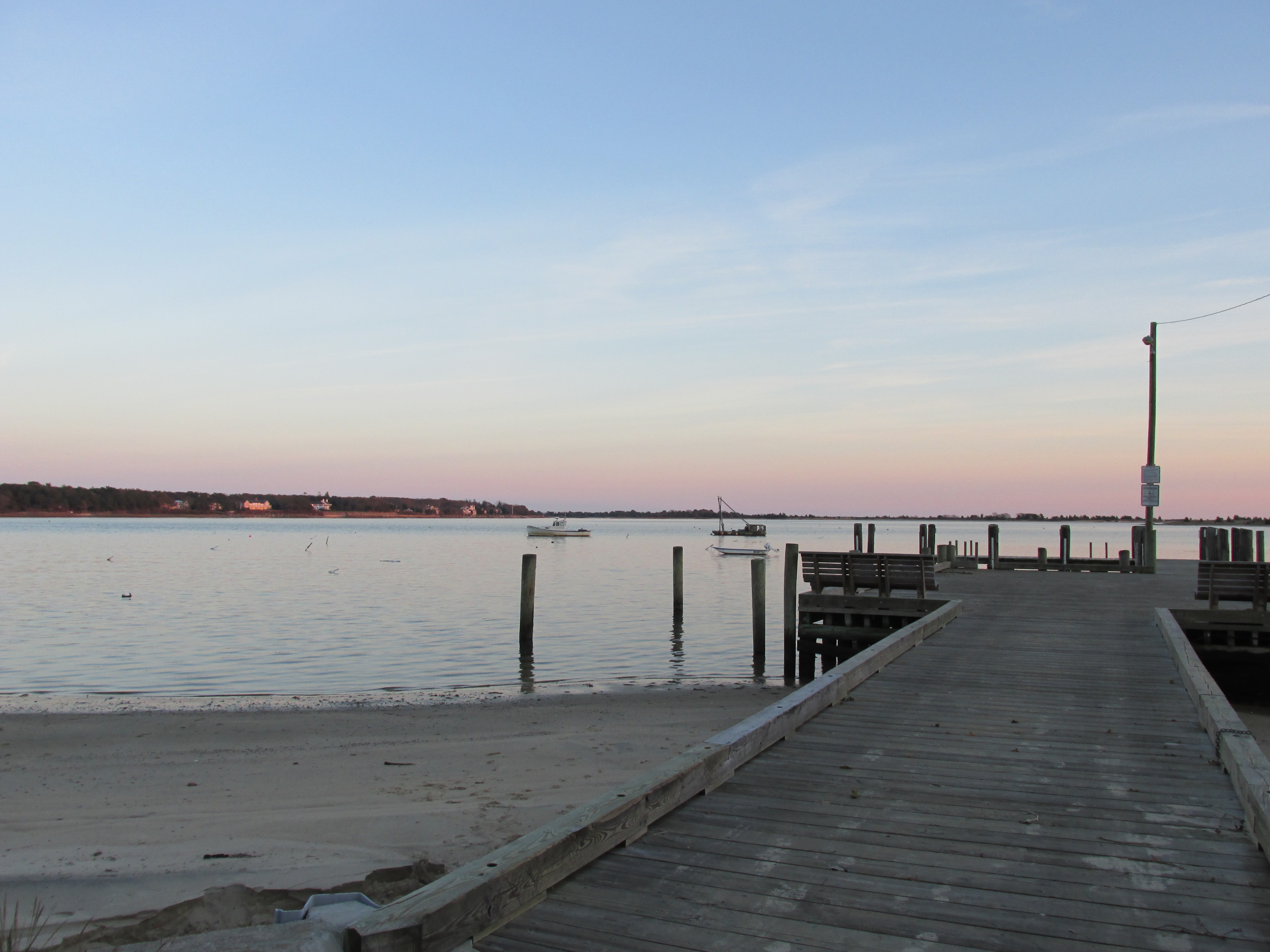 Cotuit Town Dock with small boats and shoreline buildings